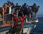 Flüchtlinge und Freiwillige helfen einer Frau von einem Holzboot am Strand von Lesbos am 7. November 2015.